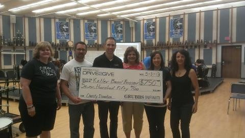 six people holding grubbs drive2give cheque