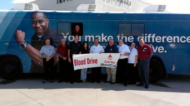 people holding blood drive banner